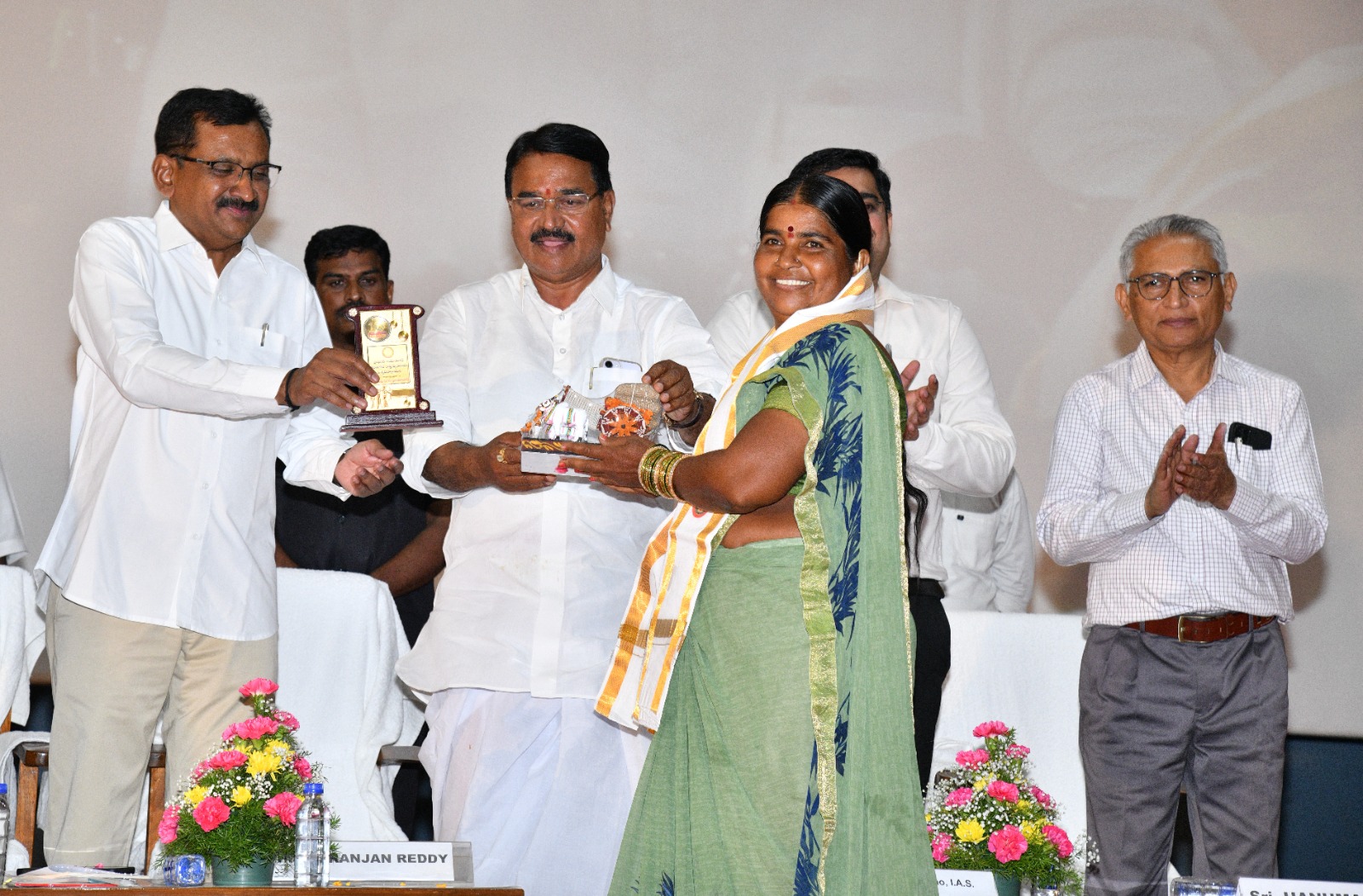 Woman farmer receiving award from Minister Niranjan Reddy 